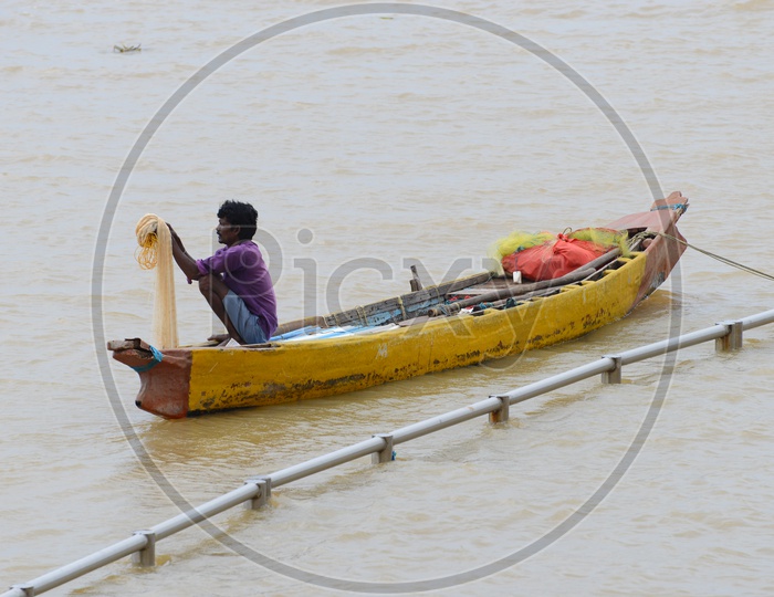 Fisherman with a net sitting in the Canoes - Krishna River