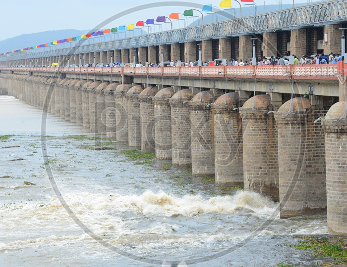 People and traffic on Prakasam barrage over Krishna river in Vijayawada. Gates opened/lifted.