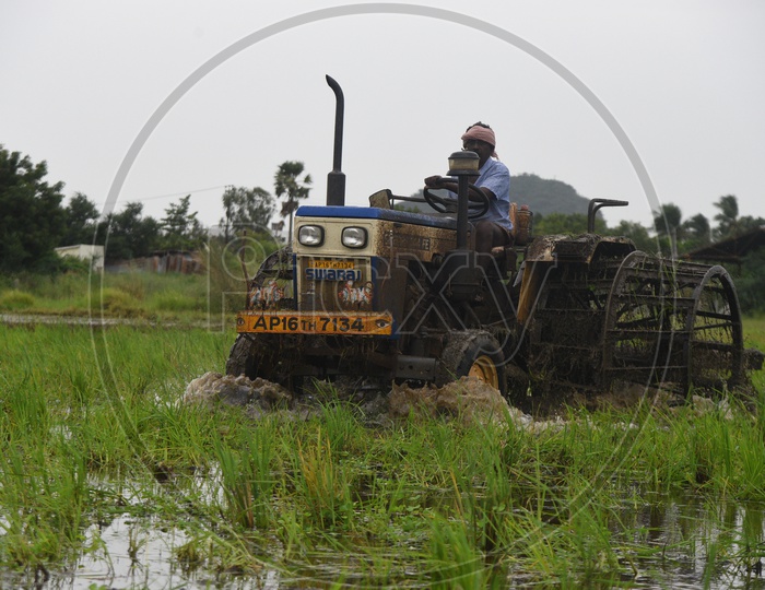 Indian Farmer working in the Agriculture field on a tractor