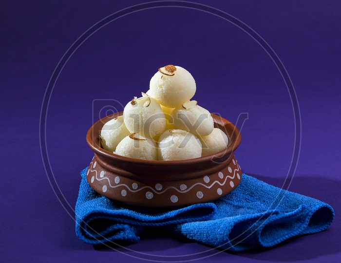 Rasgulla in a clay bowl with napkin