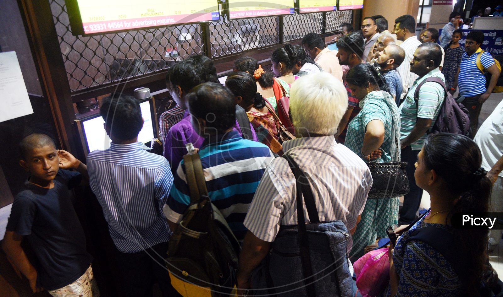 Passengers waiting in queue at a ticket counter in a bus stand