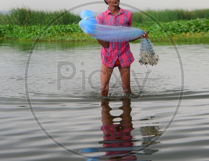 A man with the fishing net ready to cast it