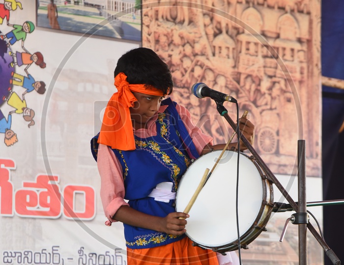 A school kid performing as a drummer on the stage