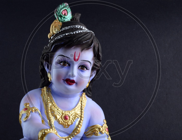 Little Krishna Idol on black background