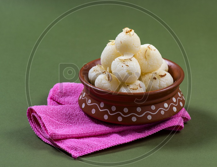 Rasgulla in a clay bowl with pink napkin