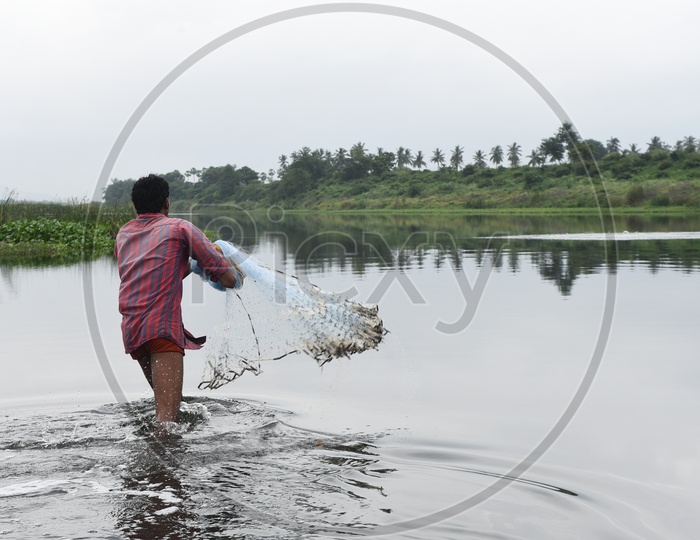 A Fisher Man With Net in a Lake