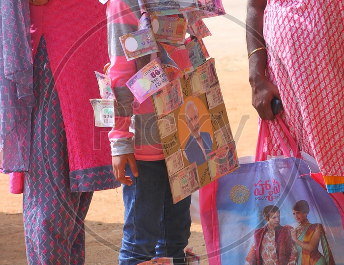 A girl child wearing money garland. Black money - Modi.