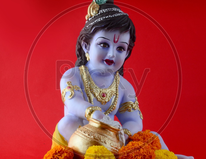 Little Krishna Idol on red background