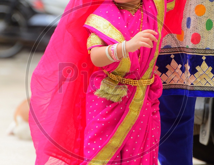 A girl child dressed up in a saree