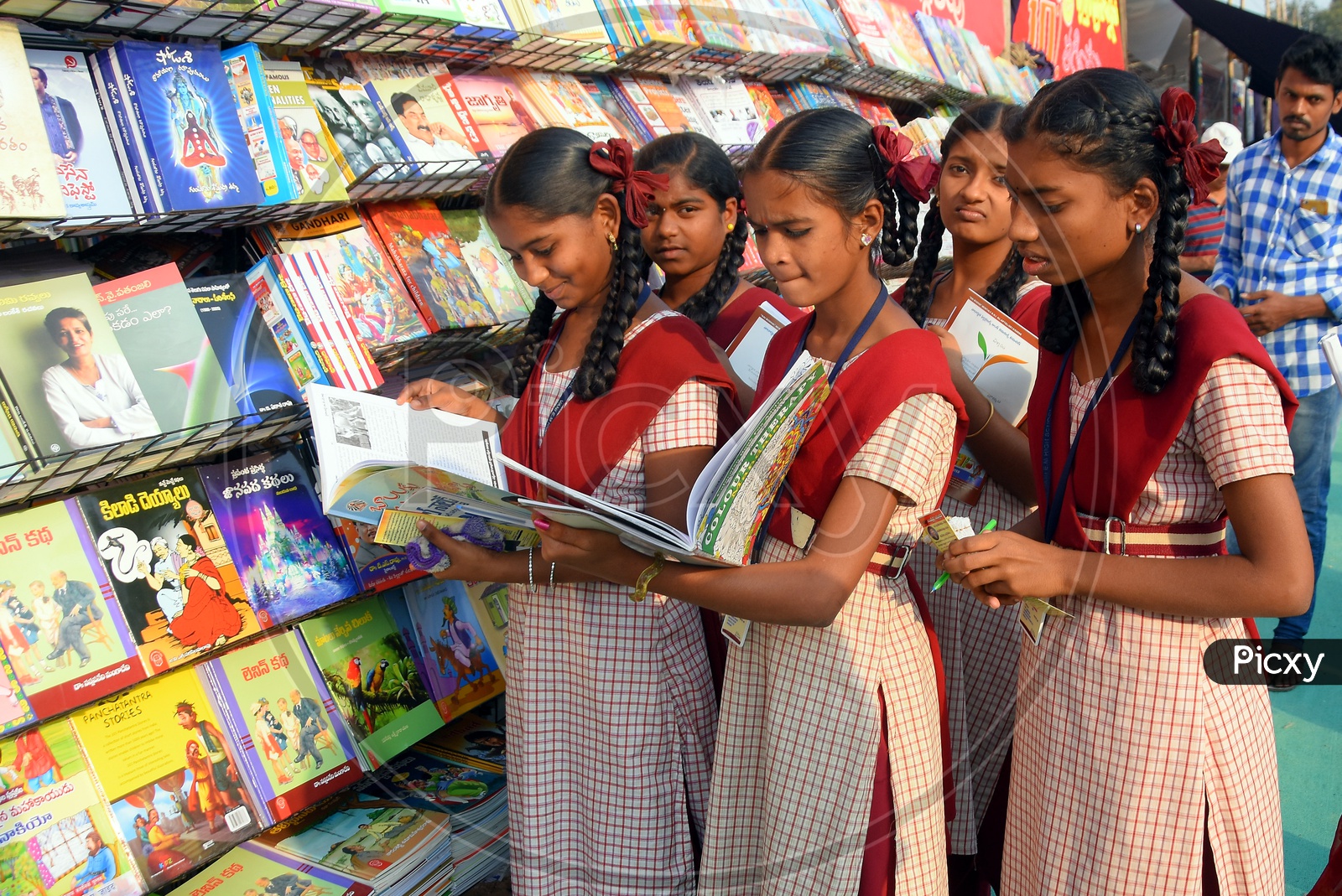 Girl Students checking out books in a book sotre