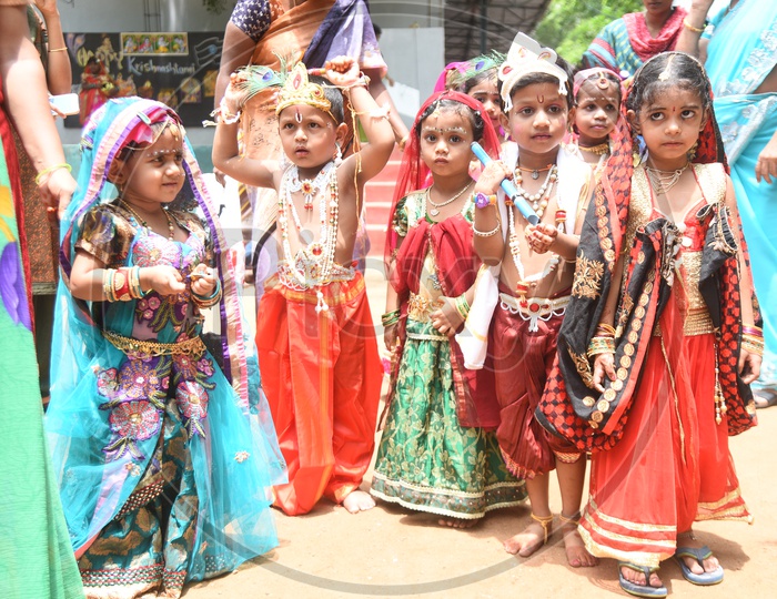 Little girls dressed as Gopika and Little boys dressed as Lord Krishna with a peacock feather on his head and a flute in his hand