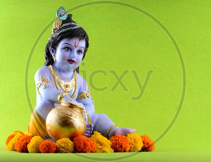 Little Krishna Idol on green background