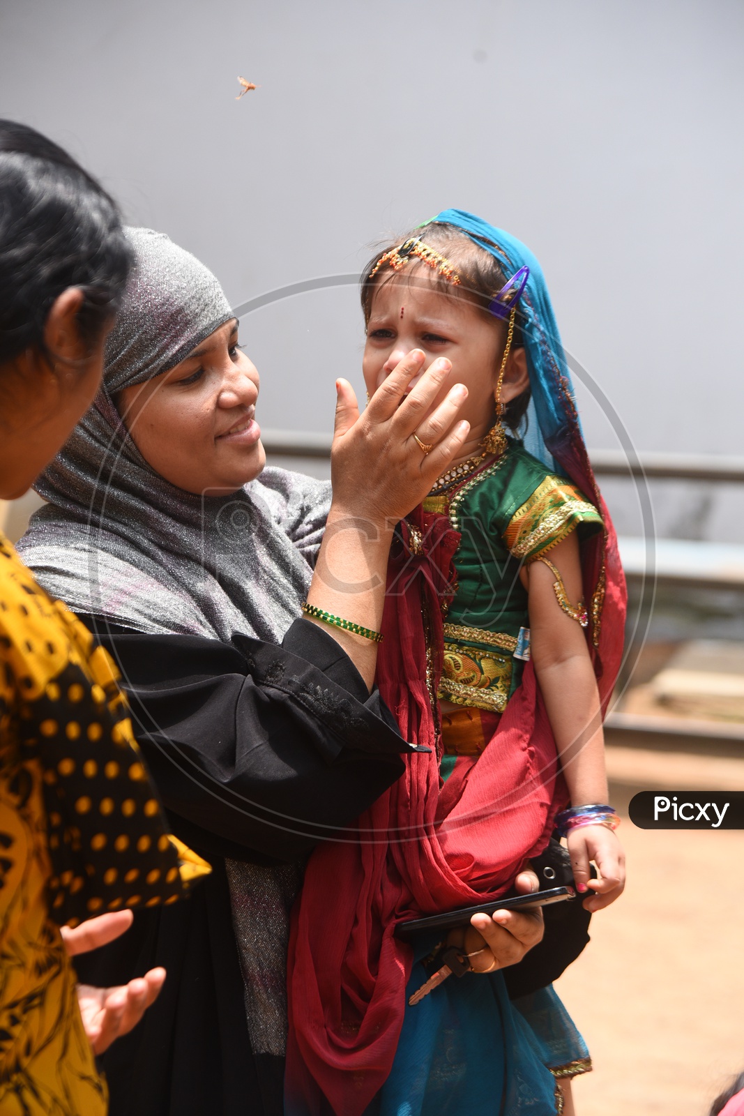 Muslim Mother With  her child who is in traditional attire and Crying
