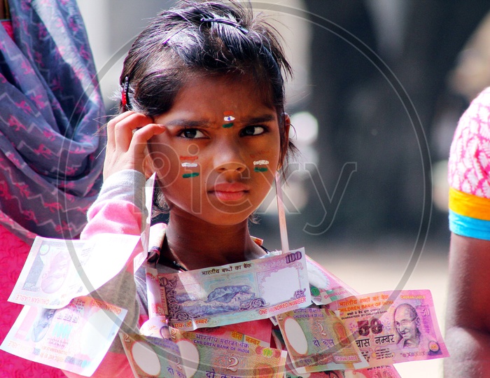 A girl child wearing money garland