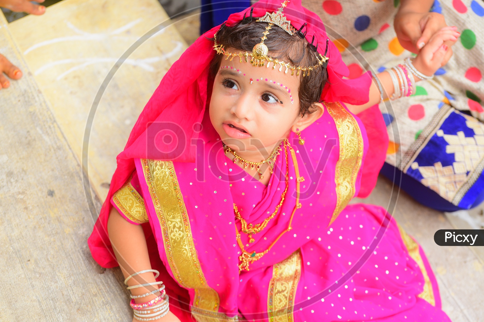 A little girl dressed as Gopika