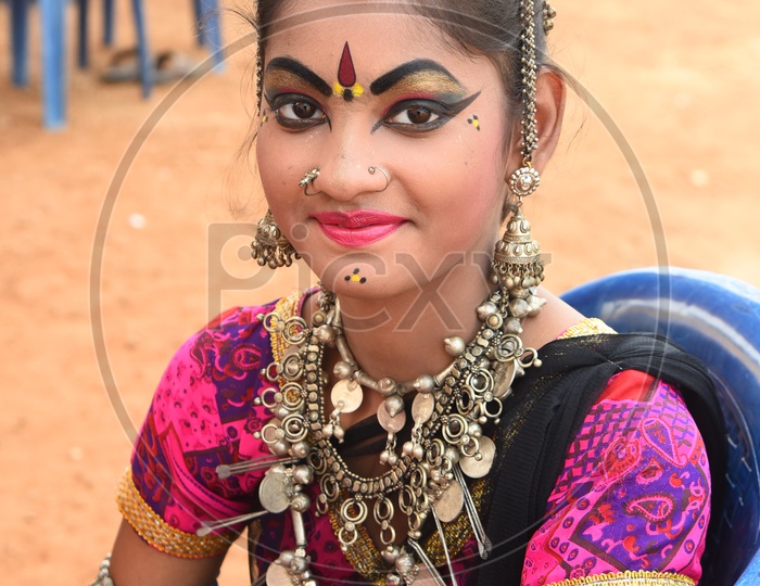 A Girl dressed up like a folk dancer with metal jewelry