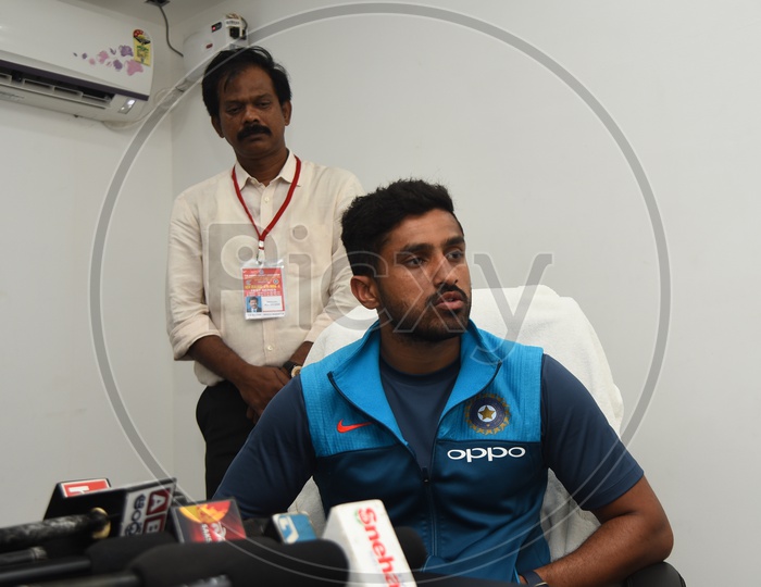 Cricketer Karun Nair speaking to the media - Telugu channels mikes placed on the table