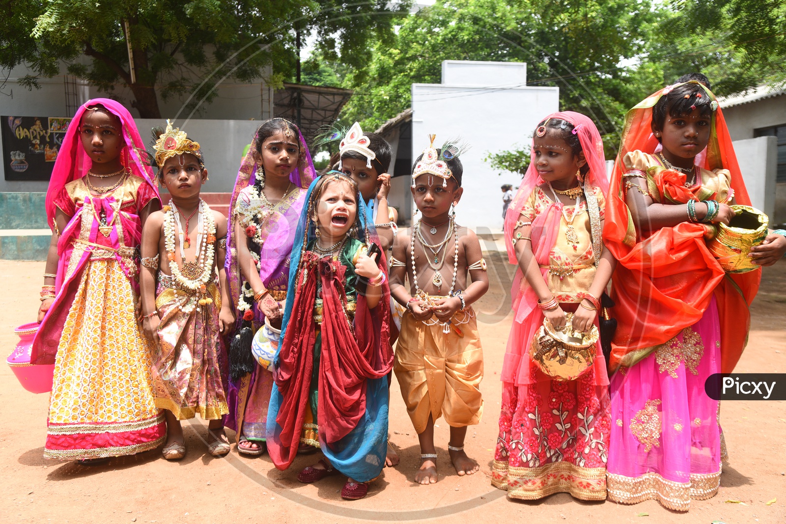 Little girls dressed as Gopika with pots in hand and Little boys dressed as Lord Krishna with a peacock feather on his head and a flute in his hand