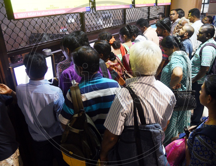 Passengers waiting in queue at a ticket counter in a bus stand
