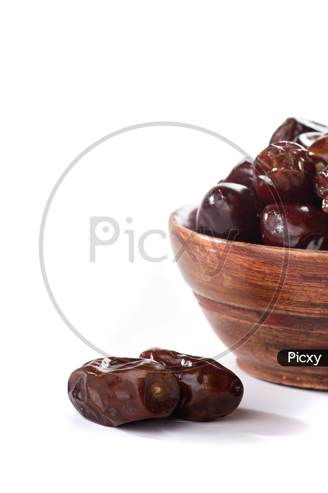 Dates in a wooden bowl isolated on a white background
