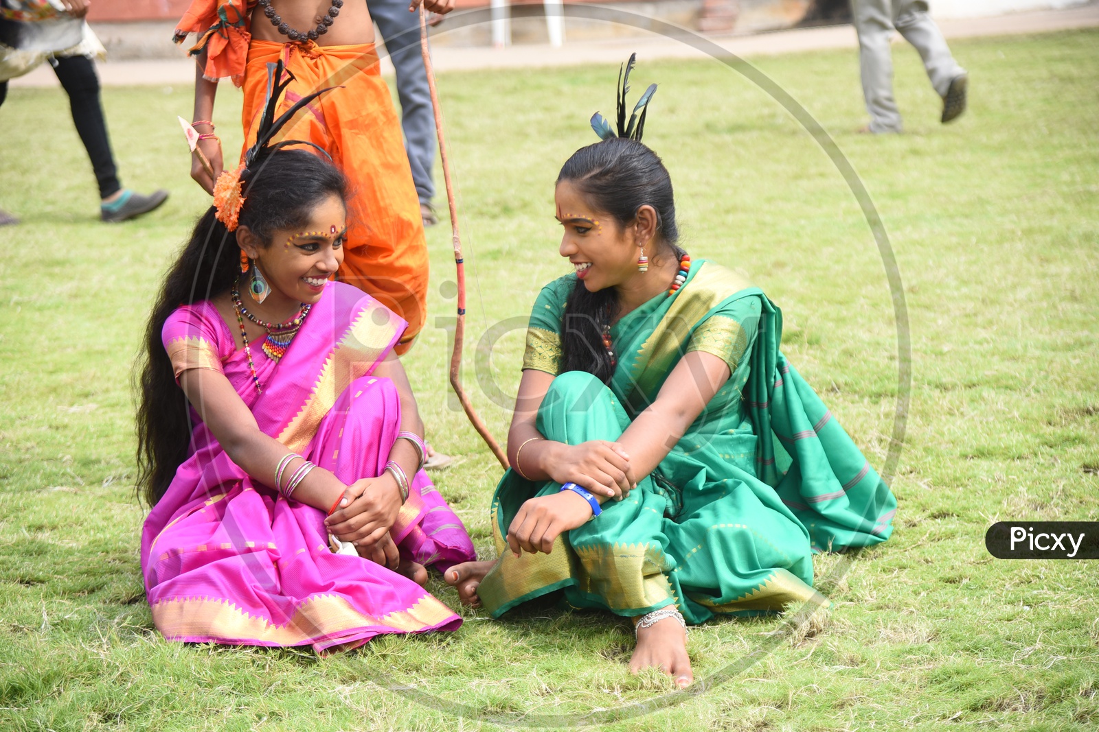 Two Costumed girls sitting on the lawn