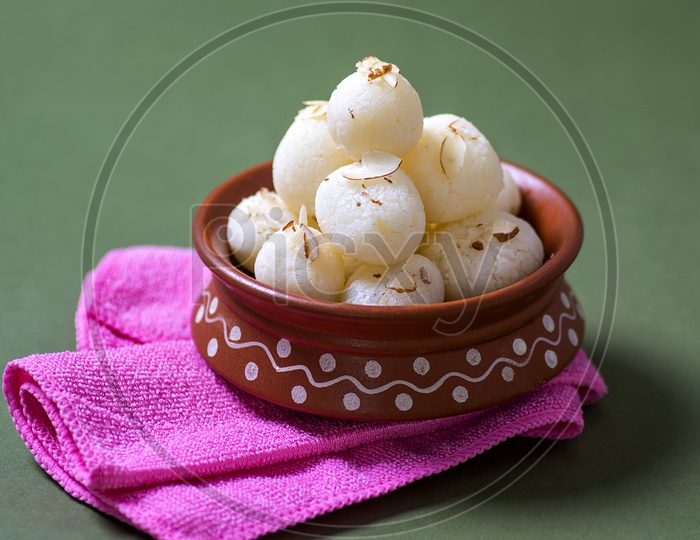 Rasgulla in a clay bowl with napkin