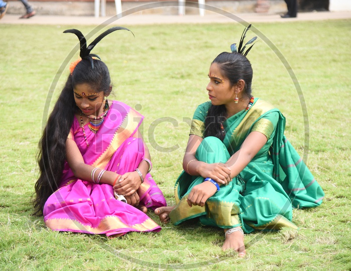 Two Costumed girls sitting on the lawn
