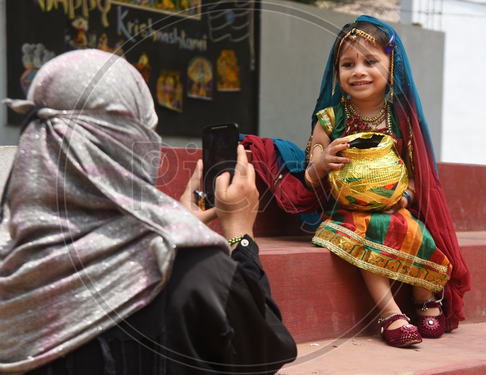 A Mother Taking A Picture Of Her Daughter who is in Traitional Attire