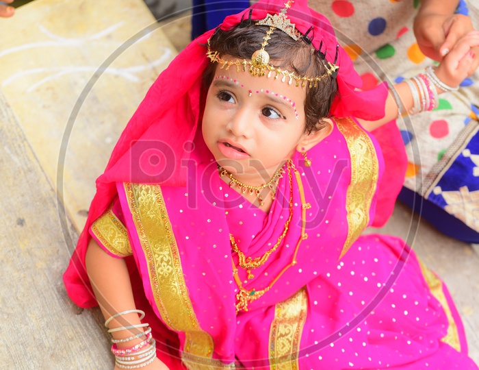 A little girl dressed as Gopika