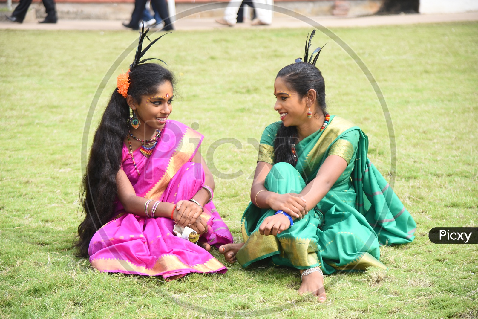 Costumed girls sitting on the lawn