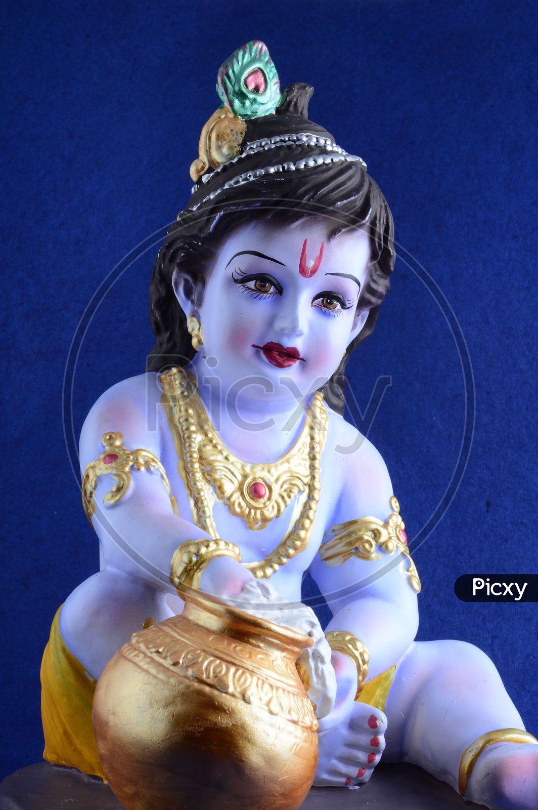 Little Krishna Idol on dark blue background