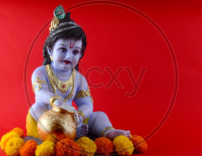 Little Krishna Idol on red background