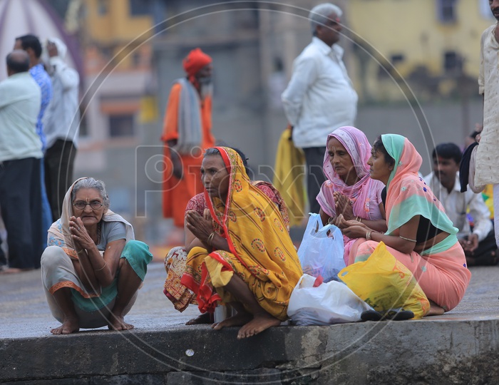 Woman Devotees Sitting Along The Ganges River Bank During Kumbh Mela