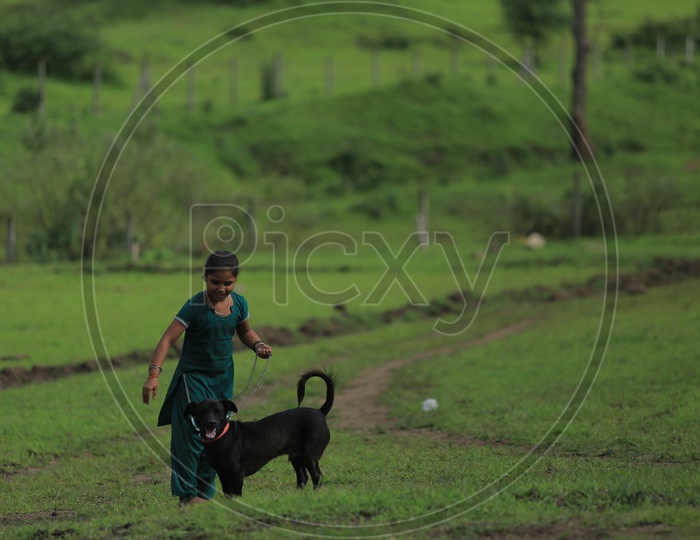A young girl with a black dog