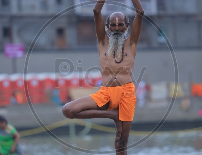 hindu Baba Or Sadhu Practicing  Siddhi Yoga Asanas on River Bank