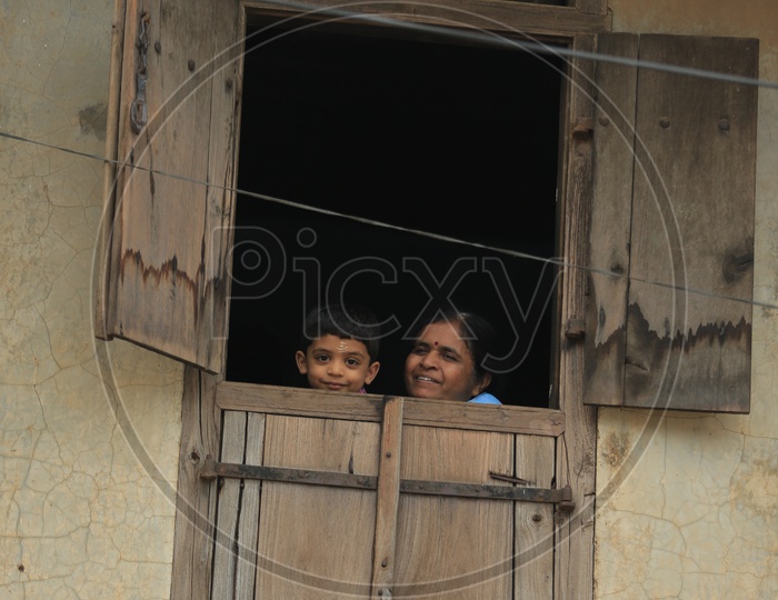 Child And Mother Looking Through The Window