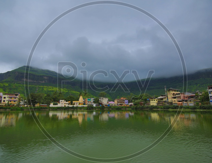 Buildings and temple in Nasik with mountains in the background on a cloudy day