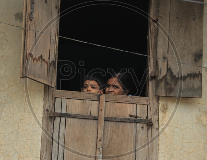A Mother And Child Looking Through Window