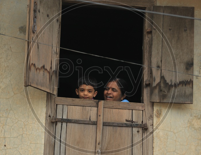 A Mother And Child Looking Through Window