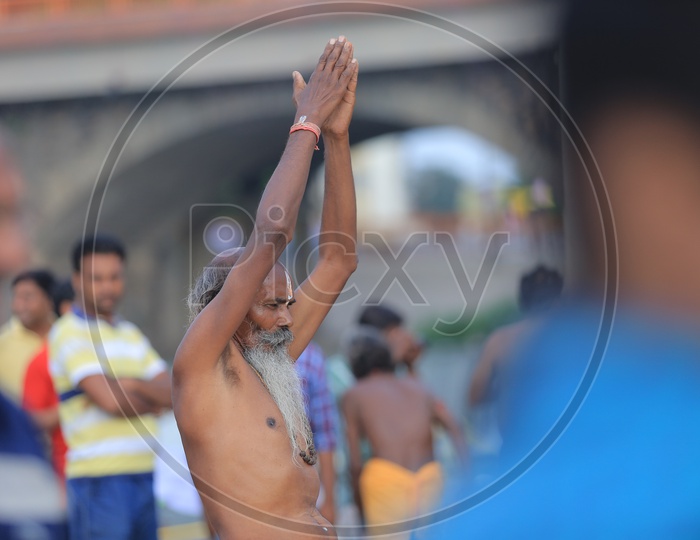 Indian Baba Or Sadhu Practicing Siddhi Yoga Asana on Ganga River Bank