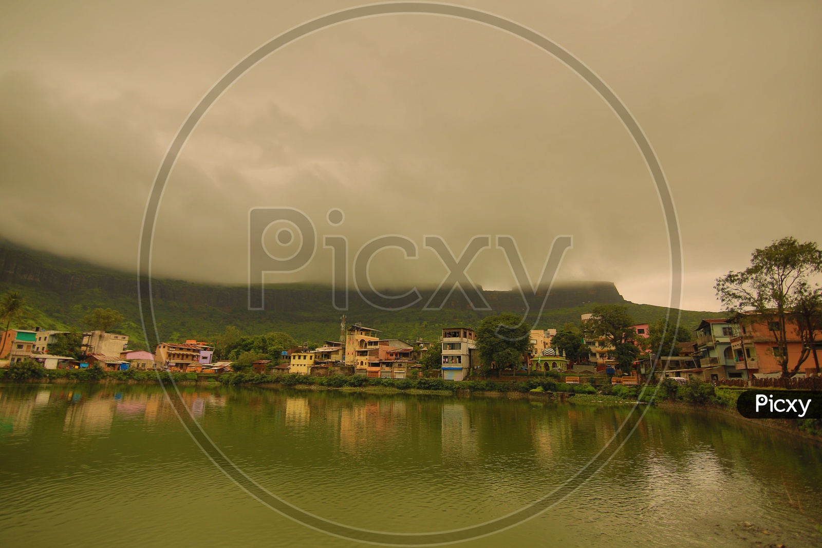 Buildings and temple in Nasik with mountains in the background on a cloudy day