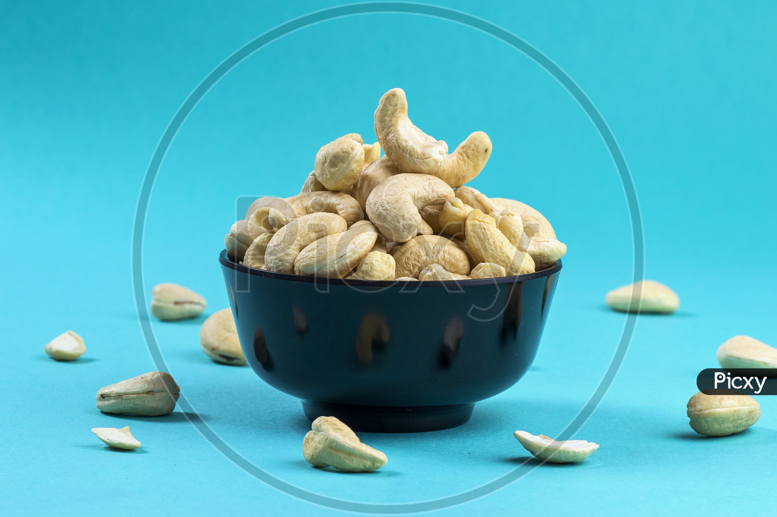 cashew nuts in a bowl on blue background