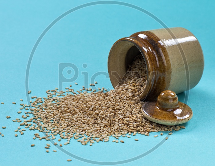 Sesame Seeds in clay pot on blue background