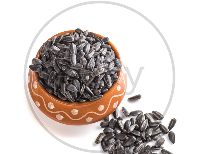 Sunflower seeds in clay bowl on a isolated white background