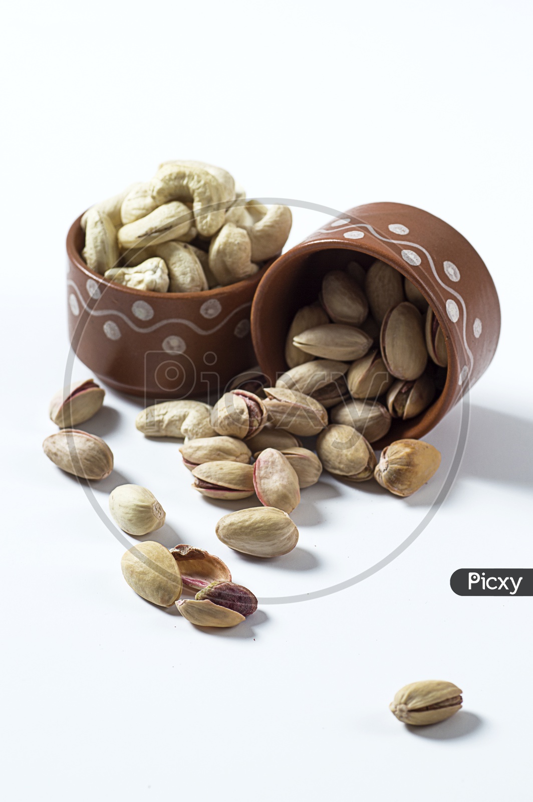 Image of Pistachio’s in a bowl on white background-DX888690-Picxy