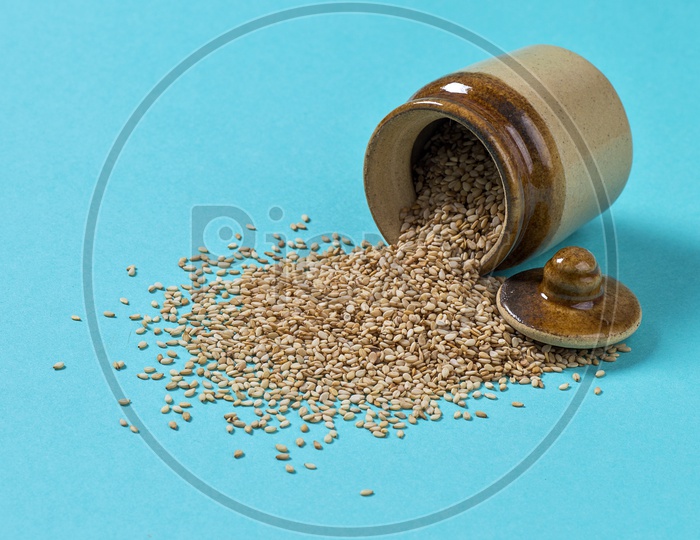 Sesame Seeds in clay pot on blue background