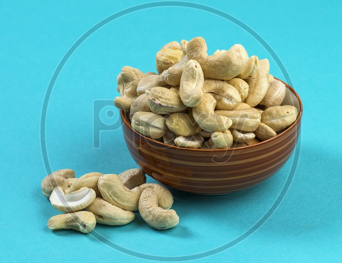 cashew nuts in a bowl on blue background