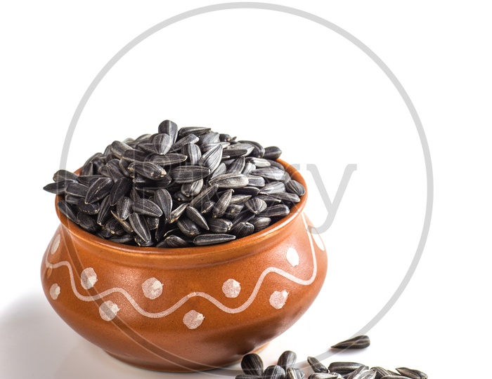 Sunflower seeds in clay bowl on a isolated white background