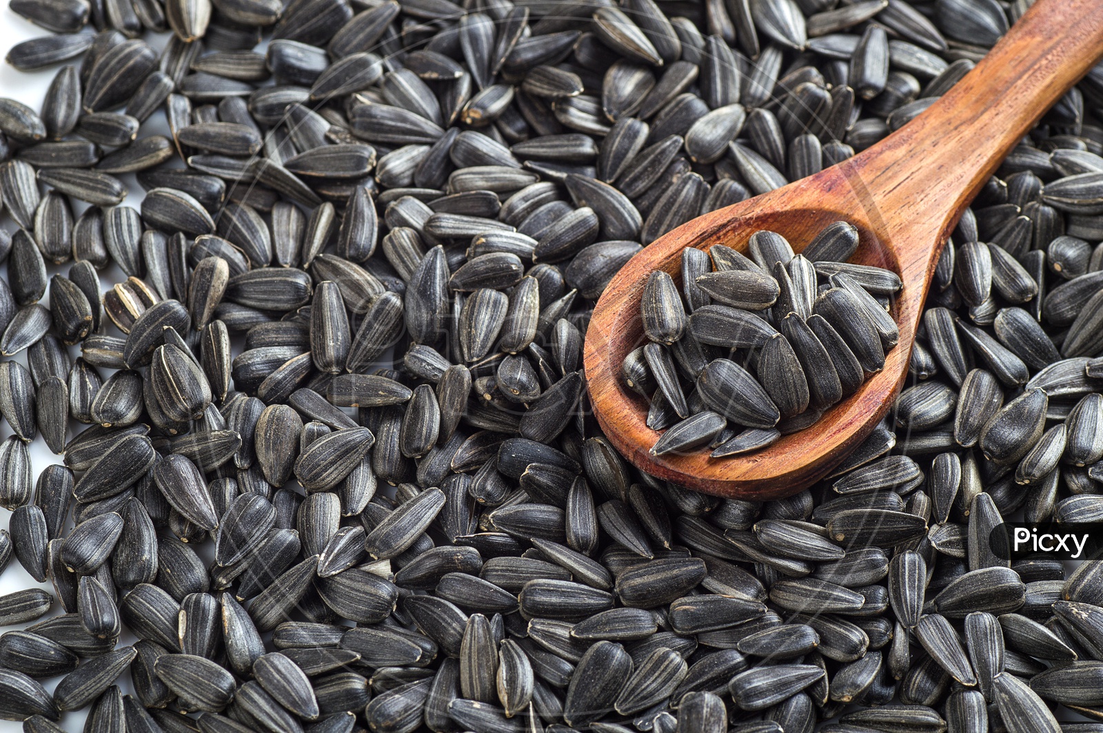 Sunflower seeds and a wooden spoon
