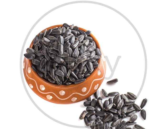 Sunflower seeds in clay bowls on a isolated white background